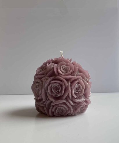 Een foto van kaars die vorm van rozen bol heeft